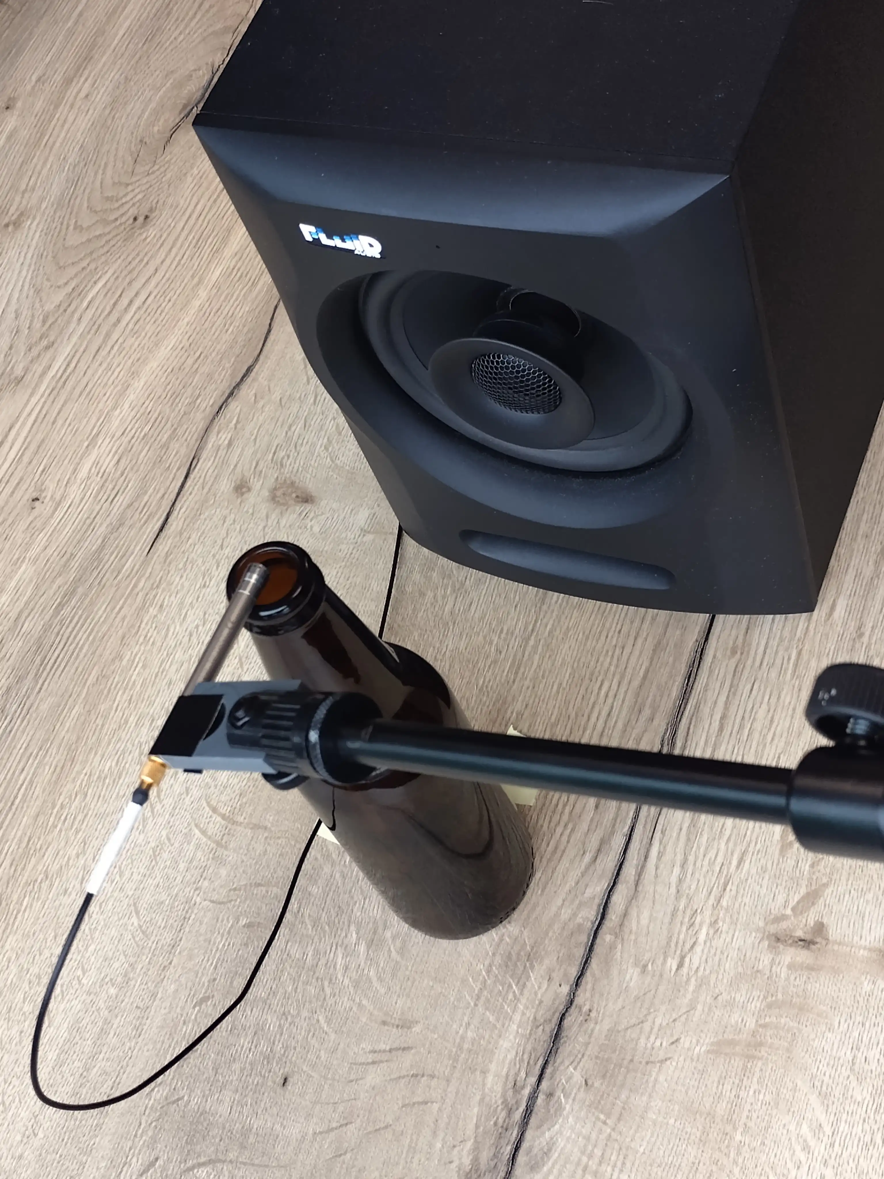 Microphone in front of a loudspeaker, with bottle